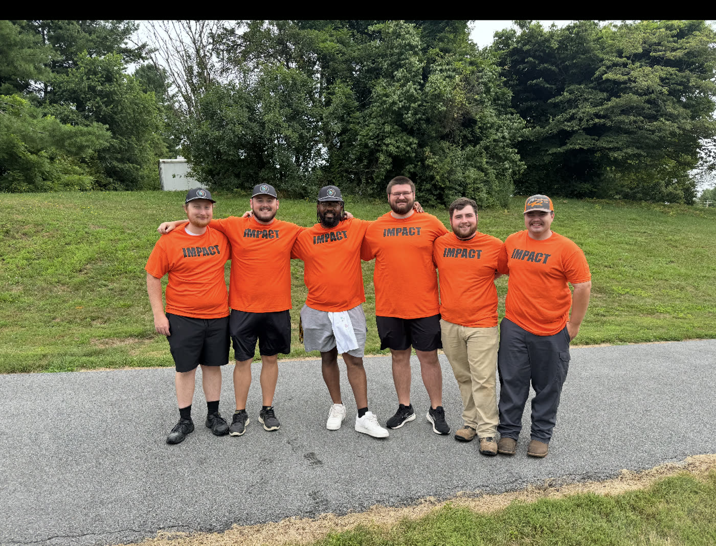 Members in orange IMPACT shirts after a service project